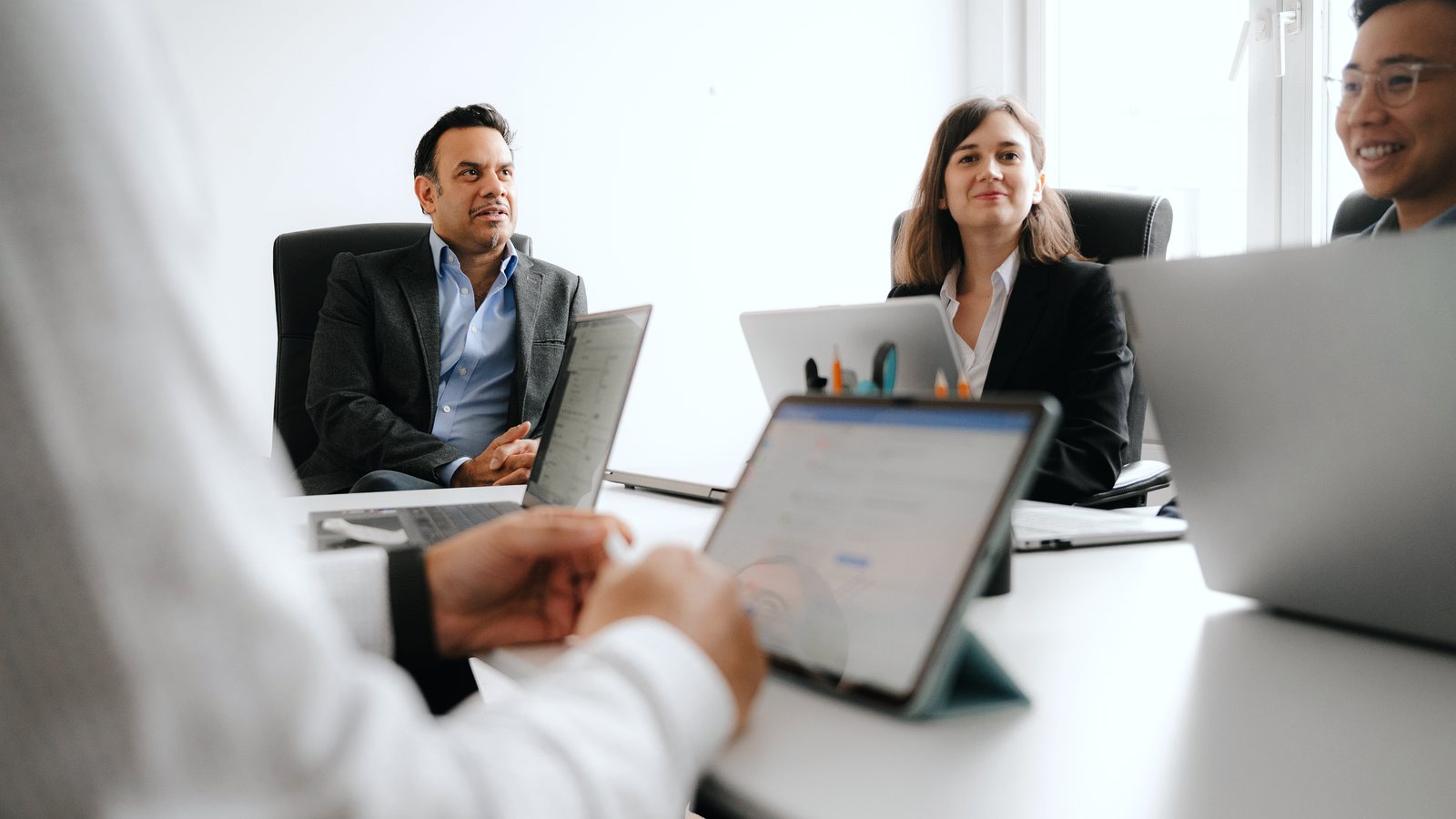 Bosenet team members working together with laptops and a tablet